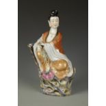 A CHINESE FAMILLE ROSE GUANYIN seated at her ease on flowers and rocks, Republic period, 14" high