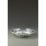 A CHINESE BLUE AND WHITE BARBER'S BOWL decorated with flowers and foliage, Qianlong, 12" long