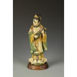 A CHINESE SANCAI-GLAZED FEMALE IMMORTAL playing a stringed instrument, Ming/Qing, 15" high