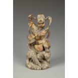 A CHINESE GILTWOOD WARRIOR-GUARDIAN seated on rocks with a tiger below, late Ming-early Qing, 10.