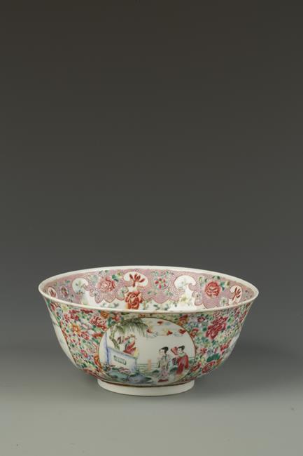 A CHINESE FAMILLE ROSE BOWL decorated with landscape roundels on a dense foliate ground, the base