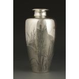 A SILVER VASE decorated with a bird perched amongst bamboo