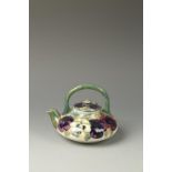 A MOORCROFT PANSY TEAPOT AND COVER