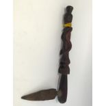 AN AFRICAN CARVED WOOD AXE with metal blade and the shaft carved in the form of a figure wearing a