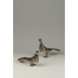 TWO WHITE METAL TABLE ORNAMENTS modelled in the form of birds, the underside of each marked "AV"