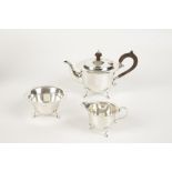 AN EDWARDIAN THREE PIECE TEA SET of shaped circular form with a wavy border, the teapot with a