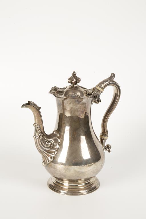 A WILLIAM IV SCOTTISH COFFEE POT of baluster form with a leaf-capped scroll handle, ivory insulators