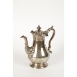 A WILLIAM IV SCOTTISH COFFEE POT of baluster form with a leaf-capped scroll handle, ivory insulators
