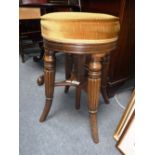 A VICTORIAN REVOLVING TOP PIANO STOOL, with upholstered seat on turned and reeded legs