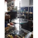A THREE TIER GLASS SHOP DISPLAY STAND