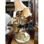 A PATINATED AND GILT BRONZE THREE BRANCH TABLE LAMP , the base mounted with a bird on a rocky