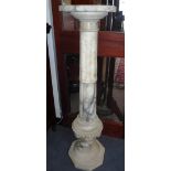 A WHITE AND VARIEGATED MARBLE COLUMN with a square top, with canted corners on a fluted pillar and