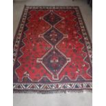 A RED GROUND PERSIAN DESIGN RUG 65" X 94" (plus fringes)