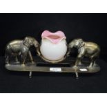 A BRASS CENTREPIECE WITH TWO CAST ELEPHANTS supporting a pink glass vase