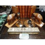 A PAIR OF CARVED HARDWOOD BOOKENDS decorated with elephants, two candlesticks and two vintage tins