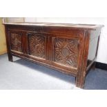 AN OAK COFFER with four panel top and three panel front, with foliate carved decoration, late 17th/