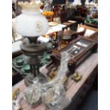 AN EDWARDIAN WALNUT WALL CLOCK, a collection of clock movements and a brass oil lamp