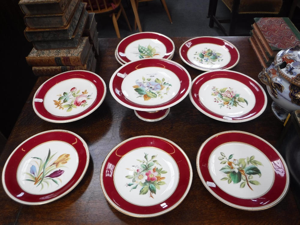 A 19TH CENTURY DESSERT SERVICE with floral specimens within a red and gilt border