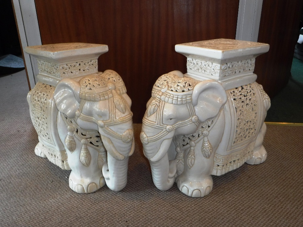 A PAIR OF ORIENTAL CREAM CERAMIC GLAZED GARDEN SEATS in the form of elephants