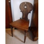 A VICTORIAN MAHOGANY HALL CHAIR with oval back above a solid seat on turned legs