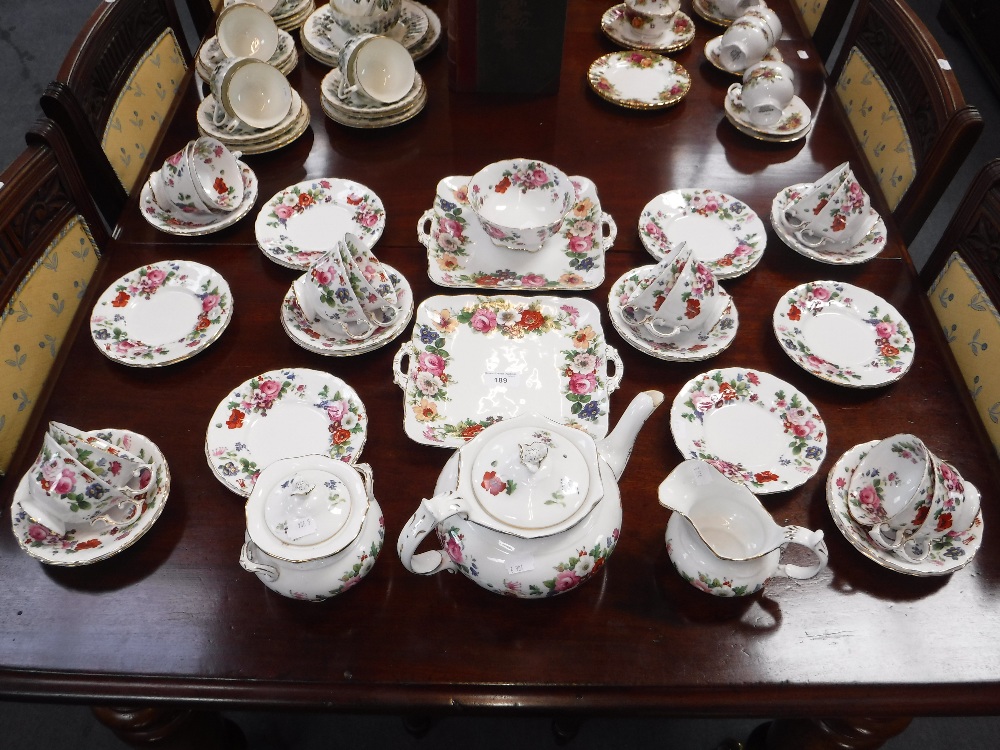 A ROCKINGHAM STYLE FLORAL TEASET with gilt decoration, to include teapot, milk jug and sucrier