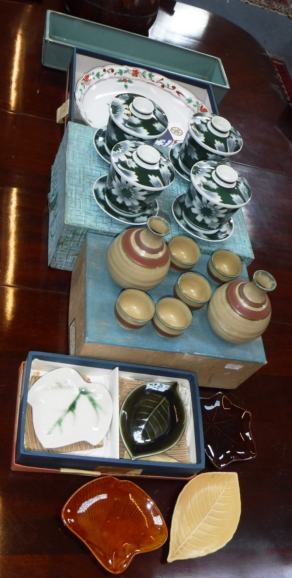 A JAPANESE SAKI SET, circa 1950 (boxed), a set of four Japanese rice bowls, with lids and saucers