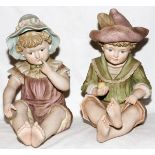 BISQUE PIANO BABIES, TWO, H 13"A seated girl wearing a bonnet and a seated boy wearing a hat. No