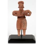 PRE-COLUMBIAN, TERRACOTTA FIGURE, H 6 1/2"A figure holding a dog. Mounted on a black painted base