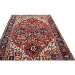 PERSIAN HERIZ HAND WOVEN WOOL RUG, W 9', L 12'Having a red ground, 4 borders, ivory and orange