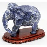 CHINESE BLUE CARVED SODALITE FIGURE OF AN ELEPHANT, H 6", L 8"On a separate wooden base. From the