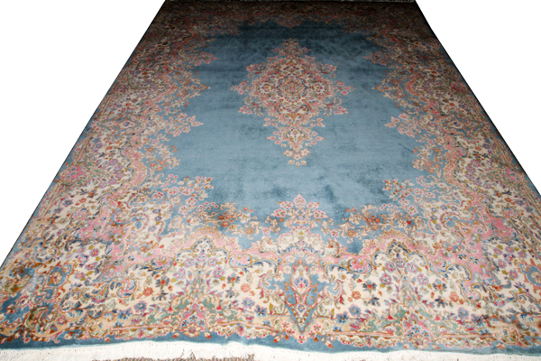 PERSIAN KERMAN WOOL CARPET, W 9' 6", L 13' 7"Having a blue field, central medallion and designs in