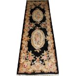 AUBUSSON DESIGN WOOL RUNNER, MODERN, L 9' 1"Having a black ground with two floral medallions and