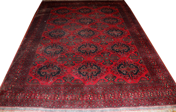 TEKKE BOKHARA WOOL CARPET, W 8' 2", L 11'An all over red ground and design.There is an area of