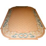 CUSTOM MADE AREA RUG W 9' L 13'Beige border with green. Salmon color field. Corners are rounded.