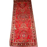PERSIAN SAROUK WOOL RUG, 6' 6" X 2' 8"Having a red field with floral designs in ivory, shades of