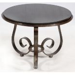 IN THE MANNER RAYMOND SUBES, BLACK GRANITE AND HAND FORGED IRON TABLE, H 19'', DIA 25''.Frame of