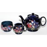 MOORCROFT ORCHID POTTERY TEAPOT, CREAMER & SUGAR BOWLTeapot, creamer and sugar bowl, all signed.