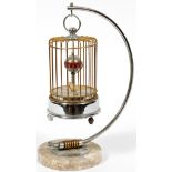 MUSICAL BIRD ANNULAR CLOCK MARBLE BASE H 8 1/2Depicts a gilt metal bird cage with a yellow bird