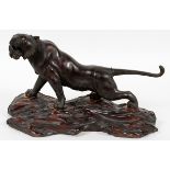 JAPANESE BRONZE TIGER, MEIJI PERIOD, H 7 1/2", L 15", SIGNED, WITH A CARVED WOOD BASEA snarling