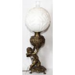 GILT METAL AND ART GLASS OIL LAMP, ELECTRIFIED, H 31''.Cupid at base with raised floral design on