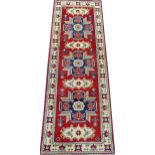 AFGHAN KAZAK RUNNER, W 2' 1", L 8' 5"Having a red ground, three borders including a wide primary