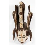 AFRICAN CARVED WOOD POLYCHROME MASK, H 23", W 12", D 12"A stylized face wearing a headdress.- For
