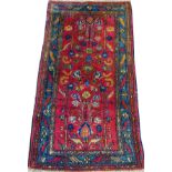 LILIHAN PERSIAN RUG, SEMI ANTIQUE, 5' 0" X 2' 6"A stylized leaf and flower motif in reds and blues.-