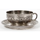 JAPANESE SILVER CUP & SAUCERCup, H 2", L 3 1/2"; saucer, Dia 5"; chased vintage and floral design.