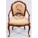 CARVED WALNUT OPEN ARMCHAIR, H 36", W 24"Having a floral needlepoint back and seat, a carved back