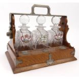 Oak three bottle tantalus with silver plated mounts, stamped 'The Tantalus Betjemayne Patent London'