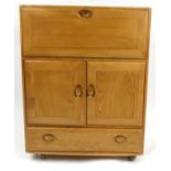 Ercol Windsor light elm drinks cabinet fitted with a fall above two cupboard doors and a drawer,