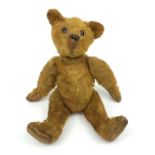 Straw filled teddy bear with beaded glass eyes, 36cm high