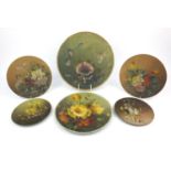 Six metal plates hand painted with still life flowers, the largest 36cm diameter