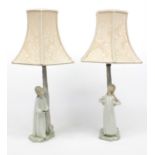 Pair of Nao figural table lamps of young girls, with shades, 53cm high including the shades